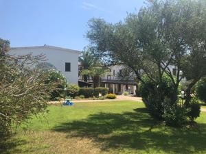 a yard with a house and a tree at White Sand Residence in Murta Maria