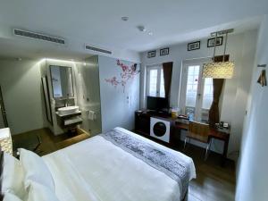 a bedroom with a white bed and white walls at Bliss Hotel Singapore in Singapore