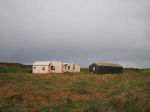 twee huizen en een schuur in een veld bij Les Refuges de Mer 