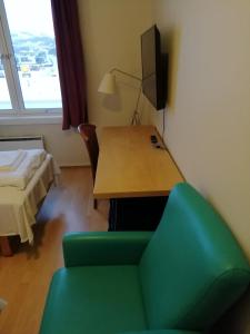 a room with a desk and a chair and a bed at Kirkenes Hotell in Kirkenes