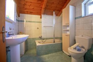 a bathroom with a sink and a toilet and a tub at Psarou Studios in Amoudi