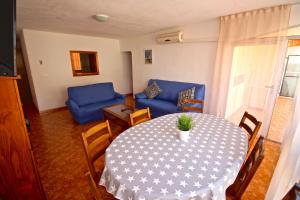 uma sala de estar com uma mesa e um sofá azul em Apartamento Benidorm 3 em Benidorm