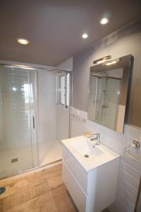 a bathroom with a white sink and a shower at Apartamento Voramar in Alicante