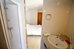een badkamer met een wastafel, een douche en een bed bij Apartamento Benidorm II in Benidorm