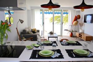 uma sala de estar com uma mesa com pratos verdes em Apartamento Cabo Azul em El Campello