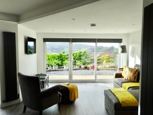 Una sala de estar con un sofá y una ventana grande. en The Kite, Upper Torrs View, en Ilfracombe