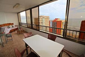a room with a table and chairs and a view of the ocean at Apartamento Arenales in Arenales del Sol