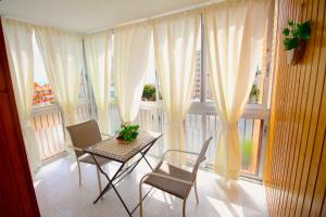 エル・カンページョにあるApartamento Las Torresの大きな窓のある客室で、テーブルと椅子が備わります。