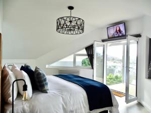 a bedroom with a white bed with a blue blanket at The Kite, Upper Torrs View in Ilfracombe