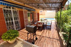 patio ze sprzętem do grillowania, stołem i krzesłami w obiekcie Bungalow Amerador w mieście El Campello