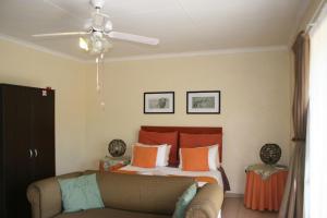 una camera da letto con un letto e un divano di Villa Royal Palm a Komatipoort Altre 9 foto