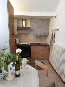 a kitchen with a table with a bottle of wine at Bed & Breakfast LA BETULLA in Baselga di Pinè