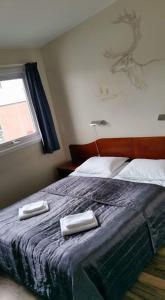 希爾科內斯的住宿－Kirkenes Hotell，一间卧室配有一张床,上面有两条毛巾