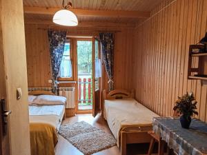 ビャウカにあるPokoje Gościnne Dudaのベッド2台と窓が備わる客室です。