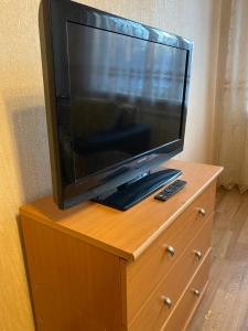 un televisor sentado en la parte superior de un tocador de madera en Домашний уют en Karagandá