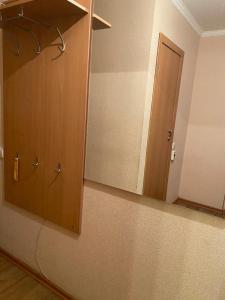 een badkamer met een spiegel en een deur in een kamer bij Домашний уют in Karagandy