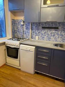 a kitchen with a stove and a sink at Домашний уют in Karagandy