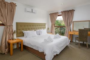 a bedroom with a bed and a desk and a mirror at San Lameer Villa 10301 - 4 Bedroom Classic - 8 pax - San Lameer Rental Agency in Southbroom +26 photos