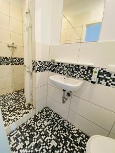 La salle de bains est pourvue d'un lavabo et de toilettes. dans l'établissement Am Lindenhof - Self Check-In Hotel, à Hanovre