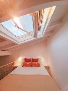 a bedroom with a bed with red pillows and a window at Casa Vinte & Cinco Alojamento Local in Penha Garcia