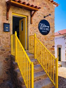 a yellow staircase leading to a building with a door at Casa Vinte & Cinco Alojamento Local in Penha Garcia