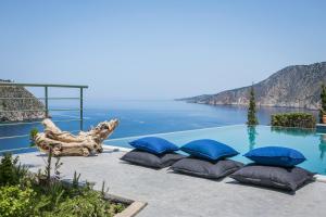 a pool with pillows and a view of the water at Braunis Horio Villas in Asos