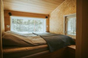 um pequeno quarto com uma cama e uma janela em Brännskär Cottages & Glamping em Pargas