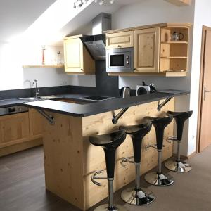 a kitchen with wooden cabinets and a counter with bar stools at Hirschberg in Haus im Ennstal