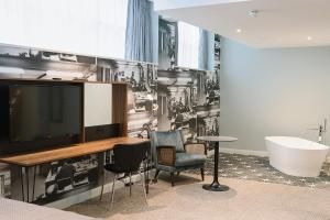 a bathroom with a tv and a bath tub at Telegraph Hotel - Coventry in Coventry