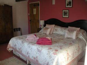 a bedroom with a large bed with pink walls at Manor Farm Oast in Winchelsea