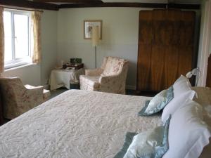 ウィンチェルシーにあるManor Farm Oastのベッドルーム1室(ベッド1台、椅子2脚、テーブル付)