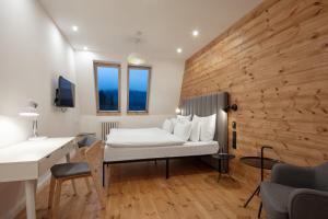 a hotel room with a bed and a desk at Pytloun Wellness Hotel Harrachov in Harrachov