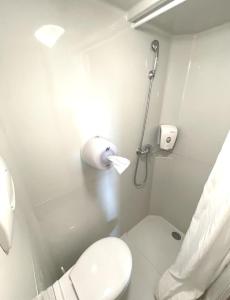 een witte badkamer met een toilet en een douche bij Première Classe Martigues in Martigues