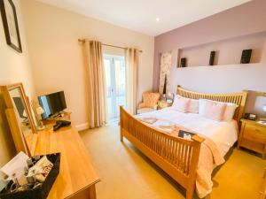 a bedroom with a bed and a desk and a television at St Giles House in Norwich