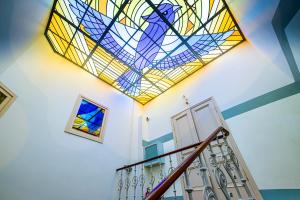 ein Buntglasfenster an der Decke einer Treppe in der Unterkunft Blue Bird Hostel in Riga Old Town in Riga