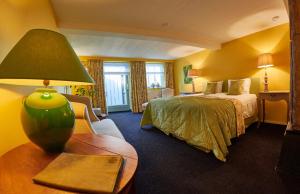 a hotel room with a bed and a lamp on a table at Boutique B&B Hoeve de Haar in Delden