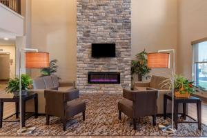 a lobby with a fireplace and a table and chairs at MainStay Suites Newberry - Crane in Odon