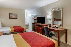 a hotel room with two beds and a desk with a computer at Econo Lodge North Charlottesville in Charlottesville