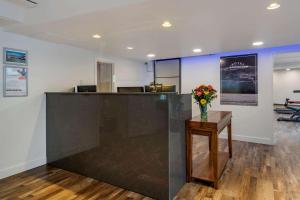 a lobby with a counter with a vase of flowers on a table at Hotel Penticton, Ascend Hotel Collection in Penticton