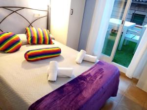 a bed with colorful pillows on it with at Hostal Termes in Sitges