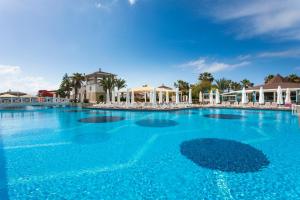 a large swimming pool with blue water at Orange County Belek in Belek