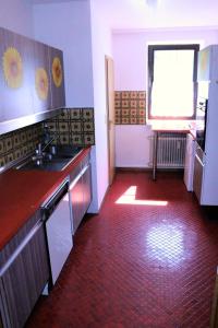uma cozinha com um lavatório e um piso vermelho em Große Wohnung im Odenwald 1 em Schönau