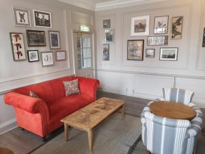 a living room with a red couch and a table at Lansdown Grove Hotel in Bath +32 photos