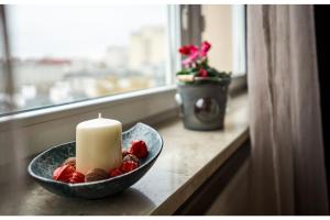 świeca na stole z truskawkami i miską owoców w obiekcie Kwiatowa Warsaw Apartment w Warszawie