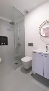 a white bathroom with a toilet and a sink at Casa Vinte & Cinco Alojamento Local in Penha Garcia