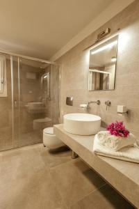 a bathroom with a sink and a toilet and a mirror at Esperance 2 in Ermoupoli