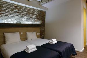 2 Betten in einem Zimmer mit weißen Handtüchern darauf in der Unterkunft City Hotel Amsterdam in Amsterdam