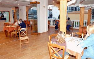Eine Gruppe von Menschen sitzt an Tischen in einem Restaurant in der Unterkunft Esperanza Hotel in Kanali