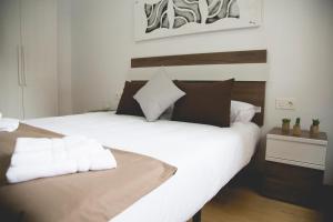 a white bed with white pillows in a room at Be Free Granada in Granada