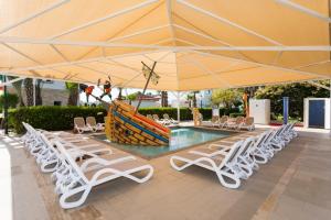a group of chairs and a pool with a large umbrella at Orange County Belek in Belek